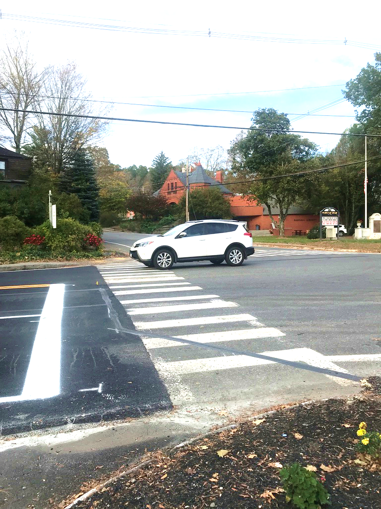 Figure 14 - Lack of Pedestrian Facilities on Southwest Intersection Corner leading to Great Road (Route 117) Crosswalk. Image is an aerial close-up of where the crosswalk meets the bed of mulch and vegetation, showing that the corner does not include sidewalks or any other pedestrian accommodations.